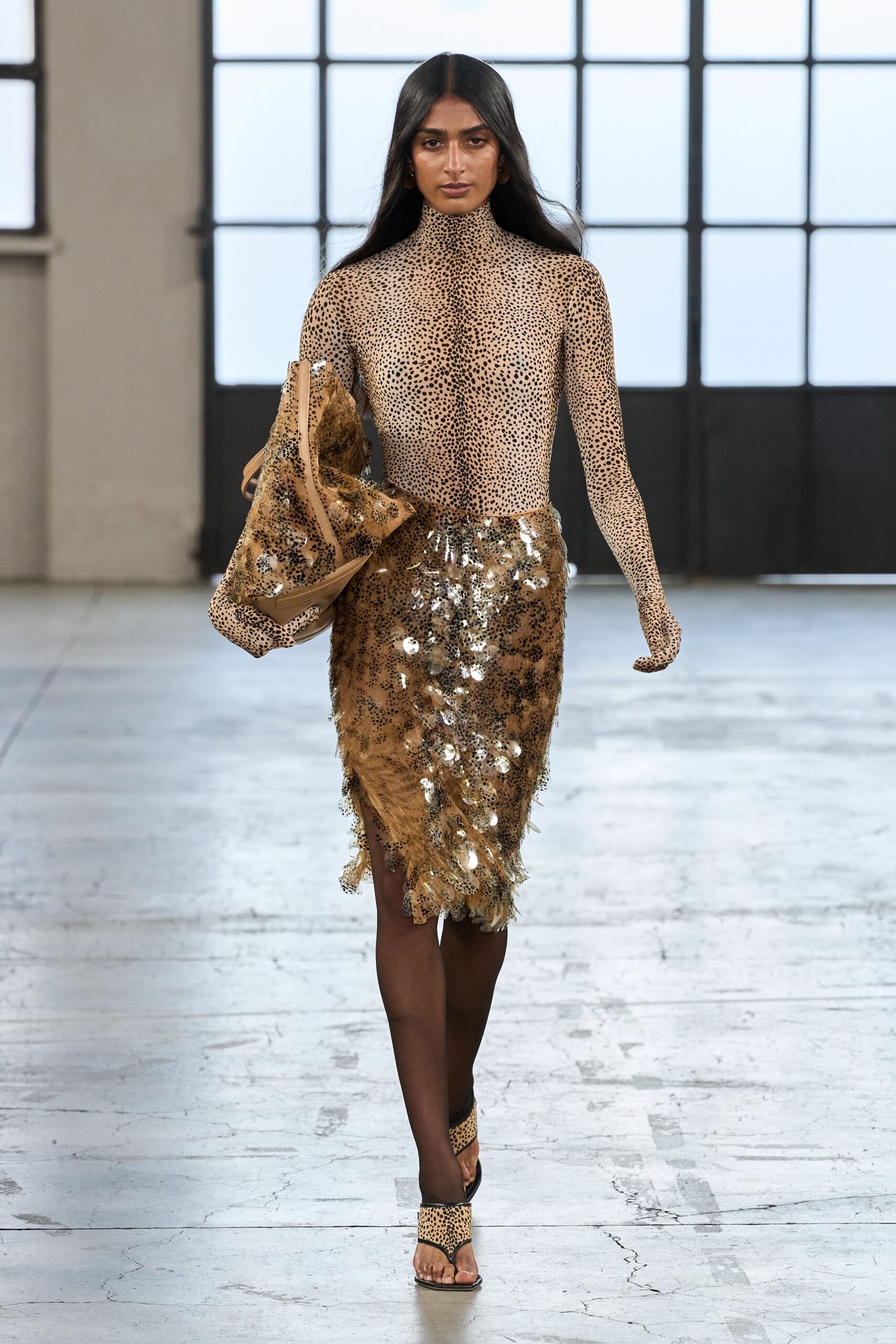 Second-skin nude bodysuit peppered with tiny cheetah spots to the fingertips. Tobacco feathered pencil skirt scattered with mirrored discs, hem fraying unevenly. Matching sequined pouch tucked under the arm. Cheetah-print thong mules over sheer black tights. For slipping from a hotel bar into the freight elevator unnoticed.