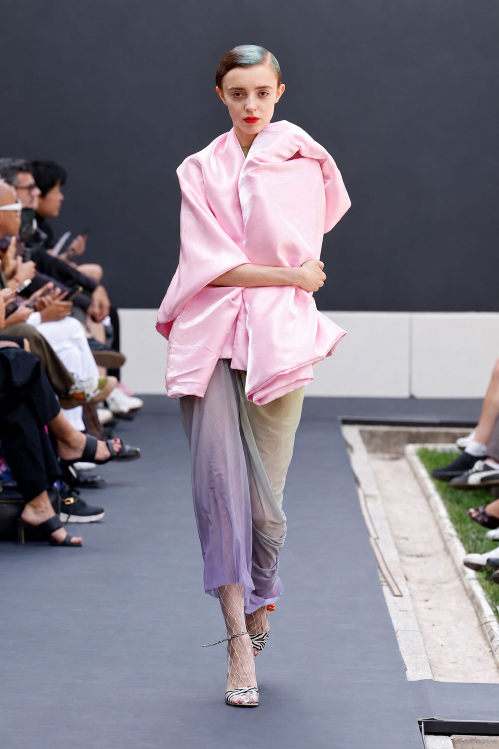 Bubblegum satin wrap, cocooned into a swollen off-center collar. Sheer taupe-to-lilac drape pooled over one leg, ruched at the ankle. Large white diamond net. Zebra-trim slingbacks with a pink floral toe. Crossing a sculpture garden after rain, shoes ticking on the path.