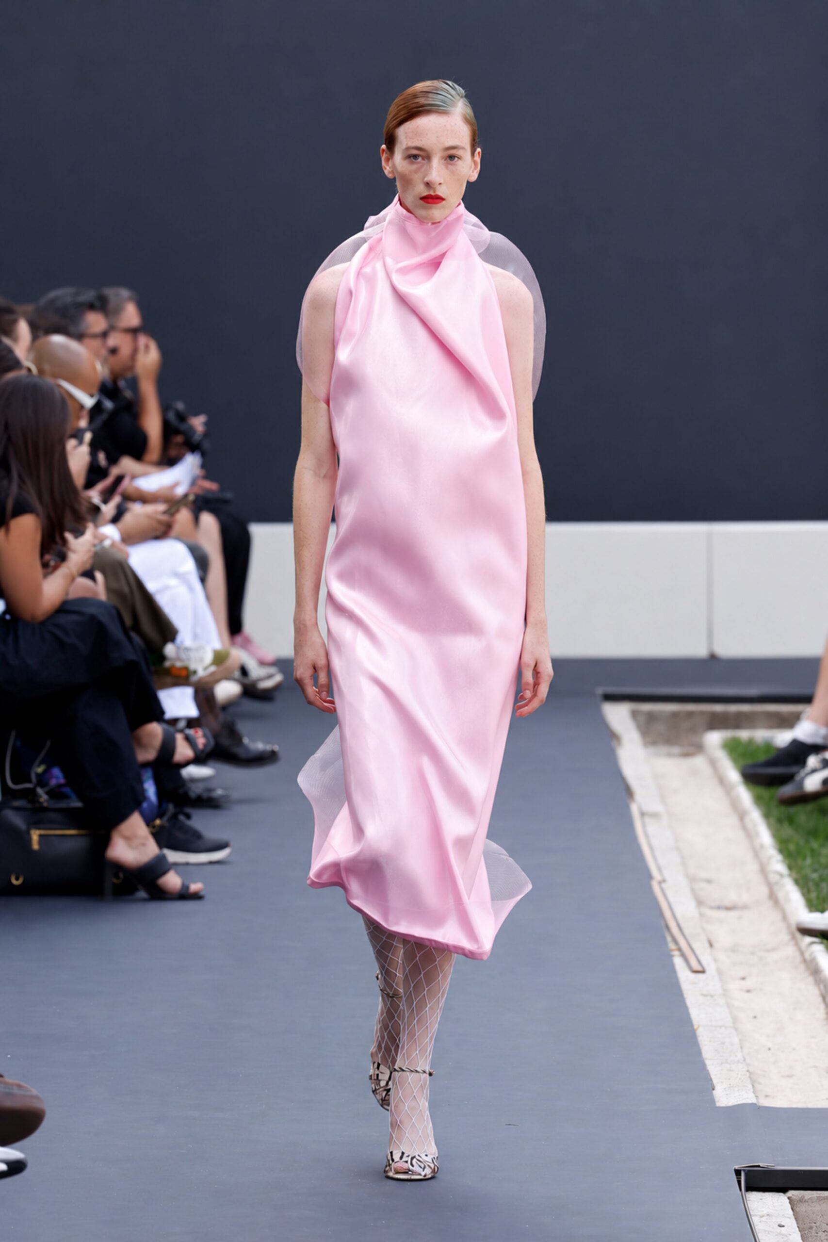 Blush satin column dress with a high neck and sheer organza loops. White diamond fishnets. Zebra-print ankle-strap heels with a peep toe. Crossing a sculpture garden after the wedding, lipstick still perfect.