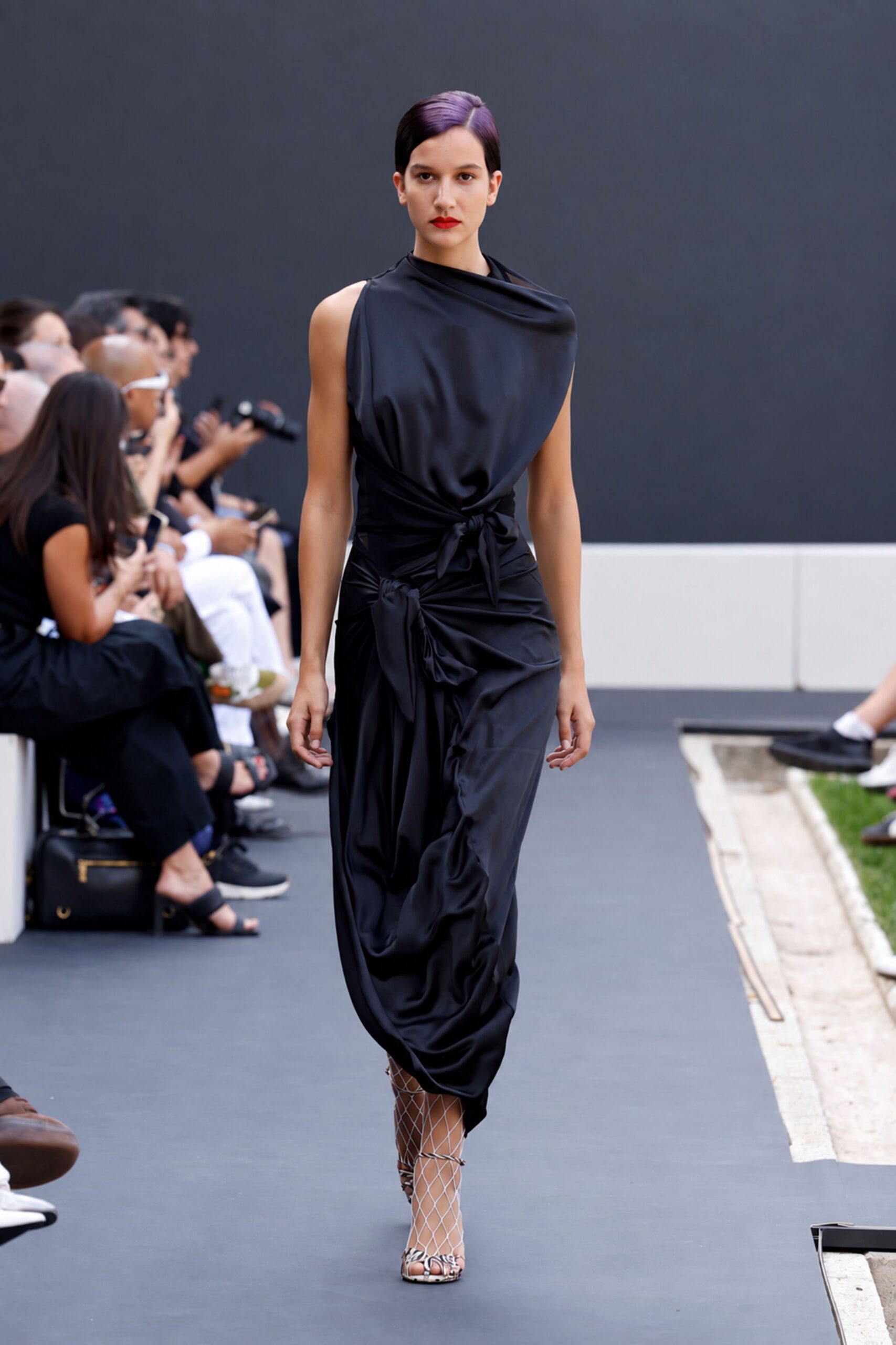 Black satin dress with a slouched cowl neck and two tied knots at the hip. Snakeskin sandals wrapped in white diamond-net overlays. For crossing a sculpture garden after dark with your shoes in the fountain spray.