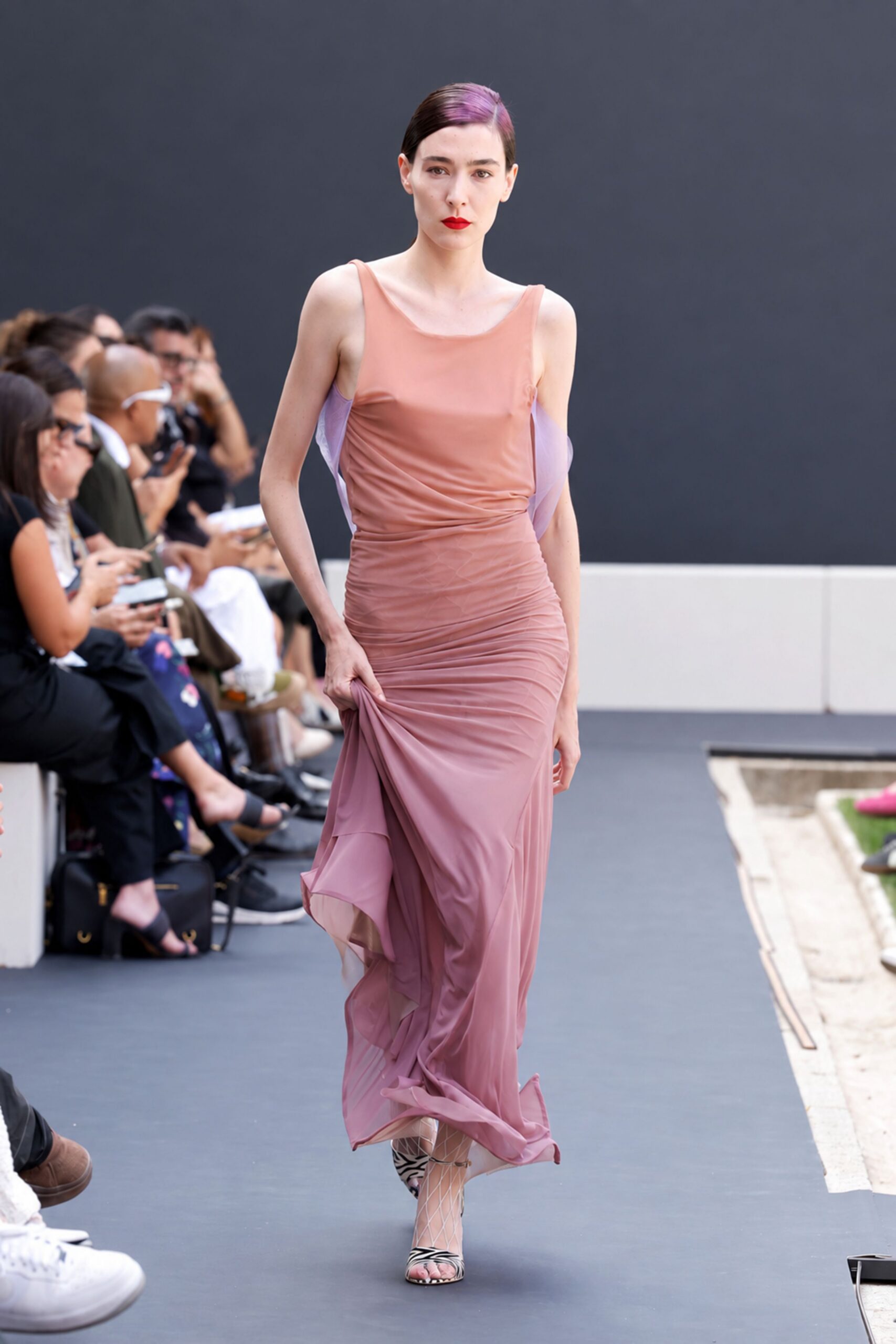Dusty rose jersey gown, side seams ruched tight through the hips. Sheer lilac chiffon wings slipping loose beneath the arms. White diamond-net stockings. Zebra-print peep-toe heels with thin ankle straps. Crossing a museum courtyard while the fountain has just been turned off.