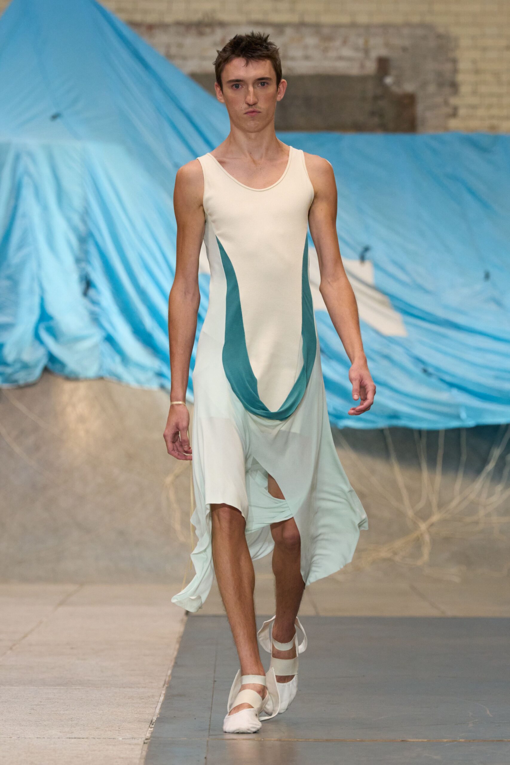 Ivory stretch jersey tank dress with sea-green panels sagging into a U. White split-toe flats bound with broad elastic straps. Crossing a boatyard in salt wind, tarp corners snapping loose.