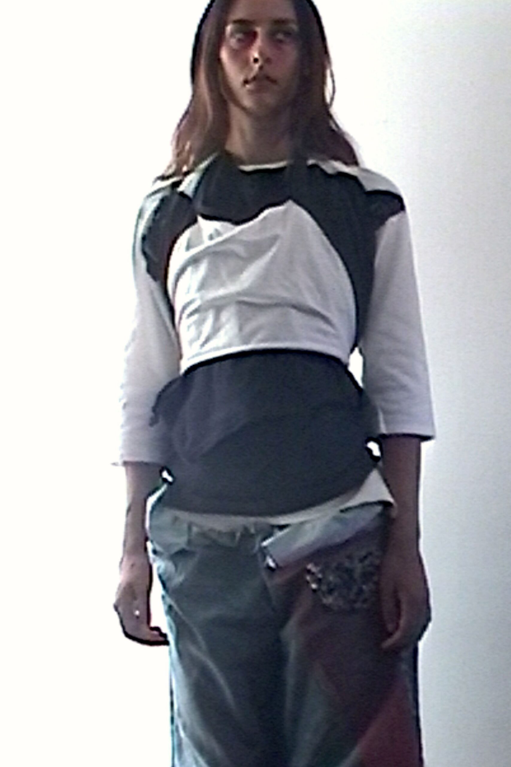 Black and white paneled knit top, cropped with a ruched bib front. Pale grey satin tube skirt, a zipped flap jutting from one hip. Clustered silver paillettes at the thigh. In a stairwell after midnight, still carrying the party on one side.