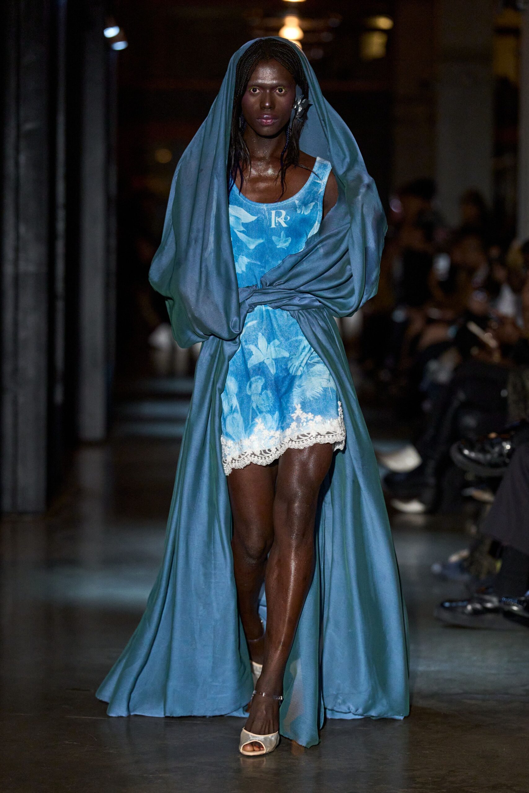 Slate-blue satin wrap knotted at the waist, pooling into a long train. Sky-blue floral romper with a scooped neck and scalloped white lace hem. Cream satin peep-toe heels with a thin ankle strap. For stepping barefoot from a hotel robe into the corridor, then changing your mind.