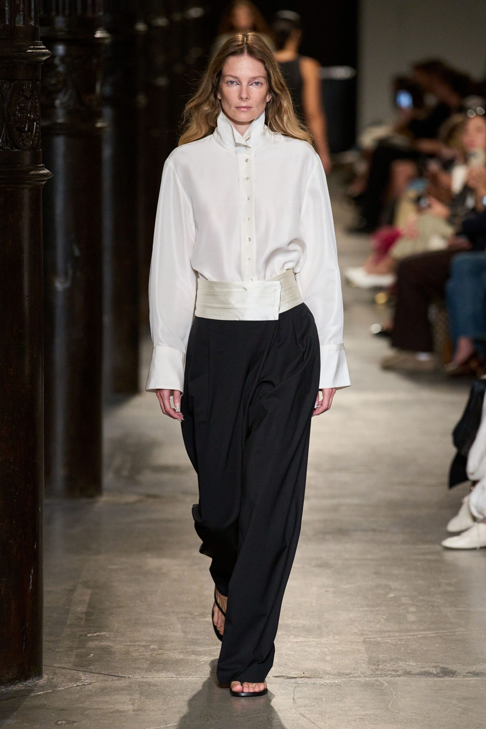Ivory blouse in fluid crepe, high stand collar and extra-long cuffs. Black draped trousers with a wide cummerbund waistband and deep front pleats. Barely there black thong sandals. For slipping out of the wedding lunch before dessert is served.