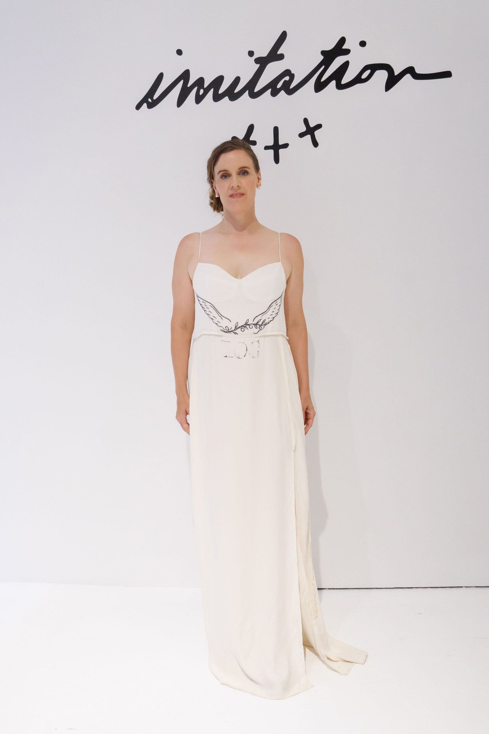 Tiny pearl drop earrings. Ivory column slip, molded bust and black winged line drawing at the waist. Registry office afternoon, bouquet still in brown paper on the car seat.