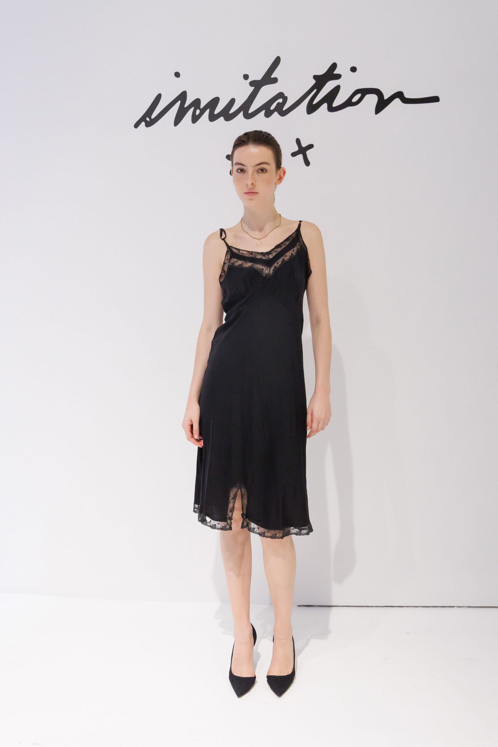 Black slip dress with sheer lace at the neckline and split hem. Fine gold chain with a small ring pendant. Black suede pumps with sharp pointed toes. For returning to a hotel bar after midnight with makeup still untouched.