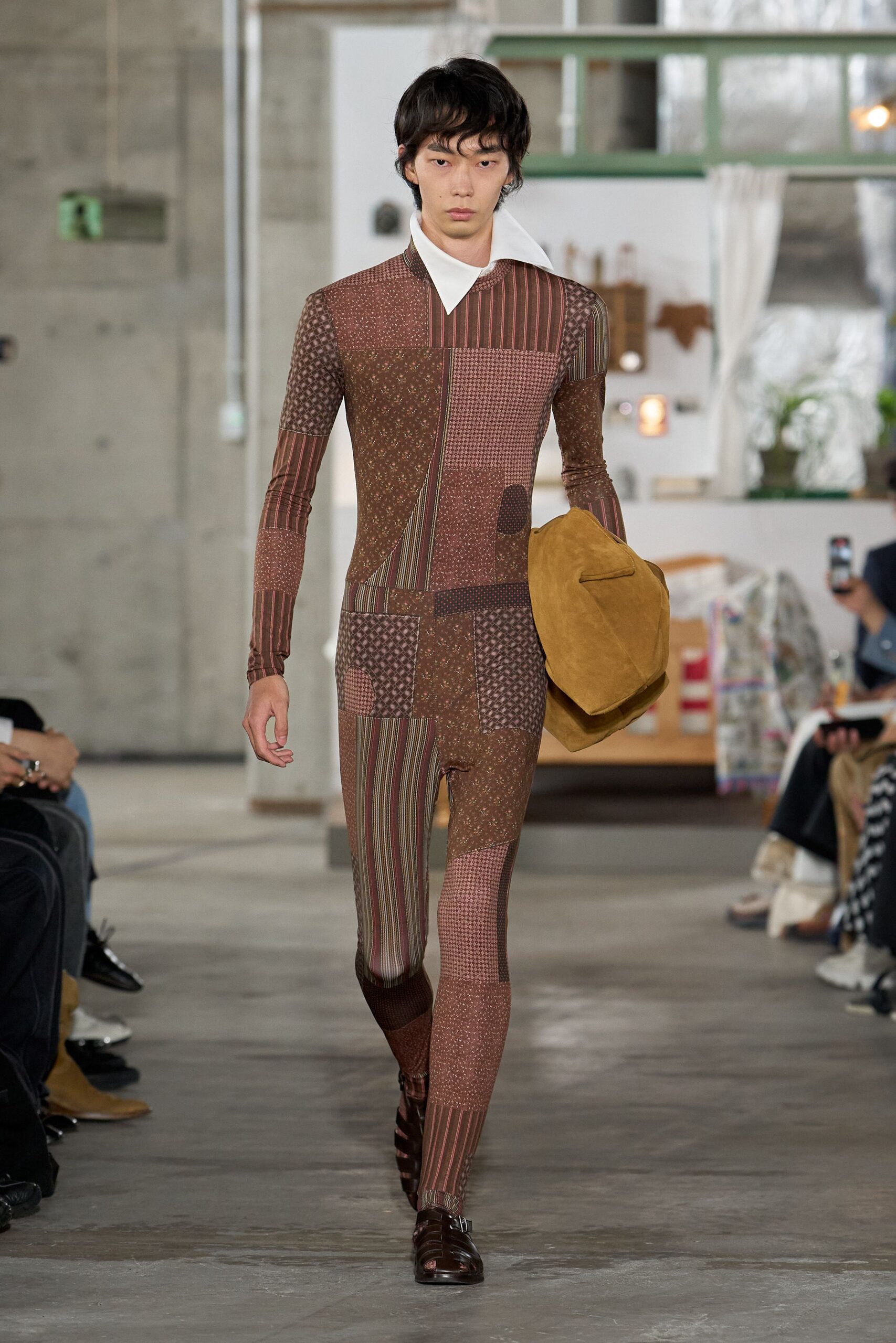 Second-skin patchwork bodysuit in dusty brown mixed stripes, checks and tiny florals. Sharp white collar flaring wide off the neckline. Slouchy ochre suede holdall tucked under one arm. Dark brown cutout leather shoes with a small side buckle. Walking back from a rural antiques fair with one good find.