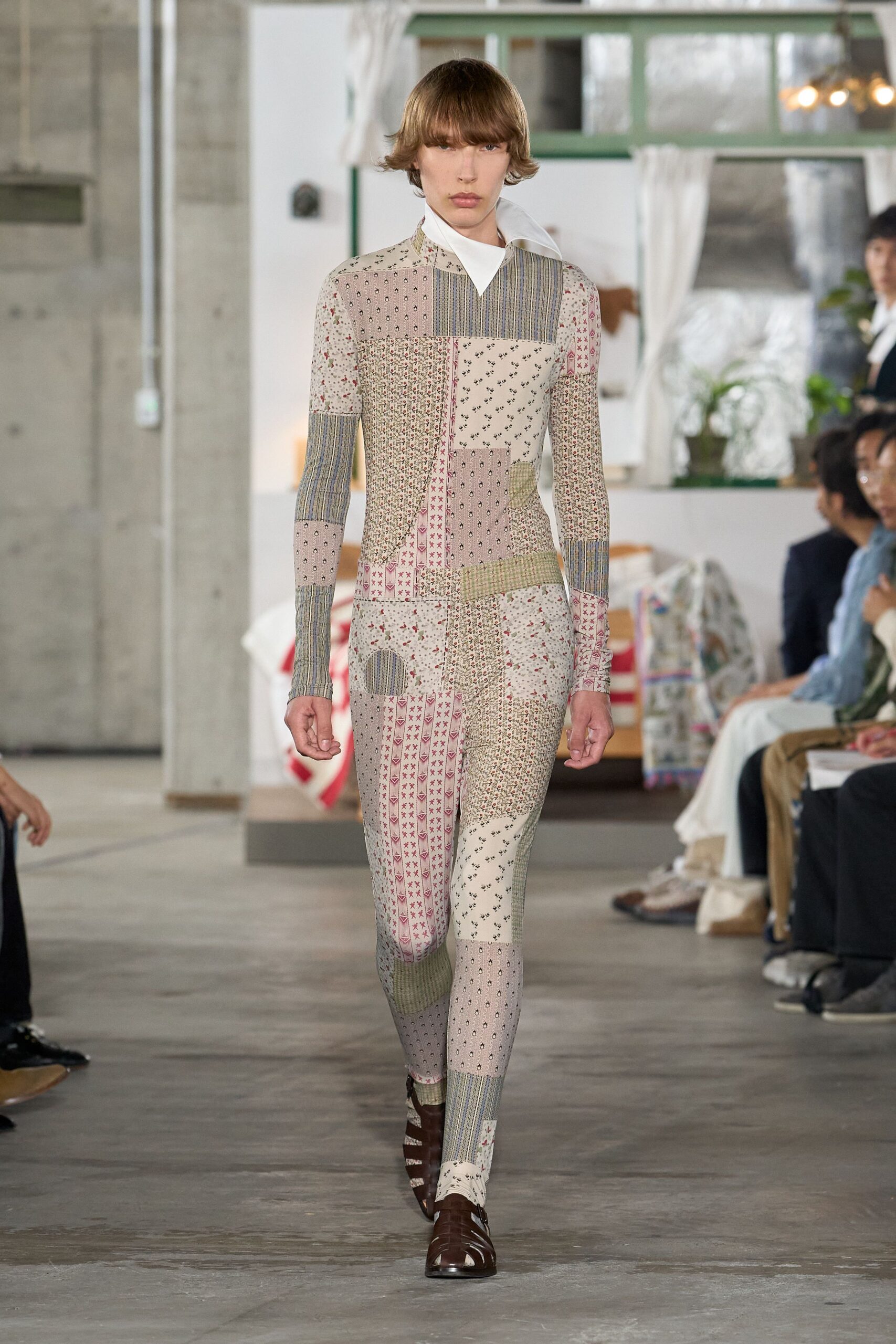 Patchwork second-skin bodysuit in mixed calico florals and ticking stripes. Crisp white pointed collar jutting high off the neck. Brown cutout leather shoes with a glossy squared toe. Sunday house tour, someone left the guest quilt draped over a chair.