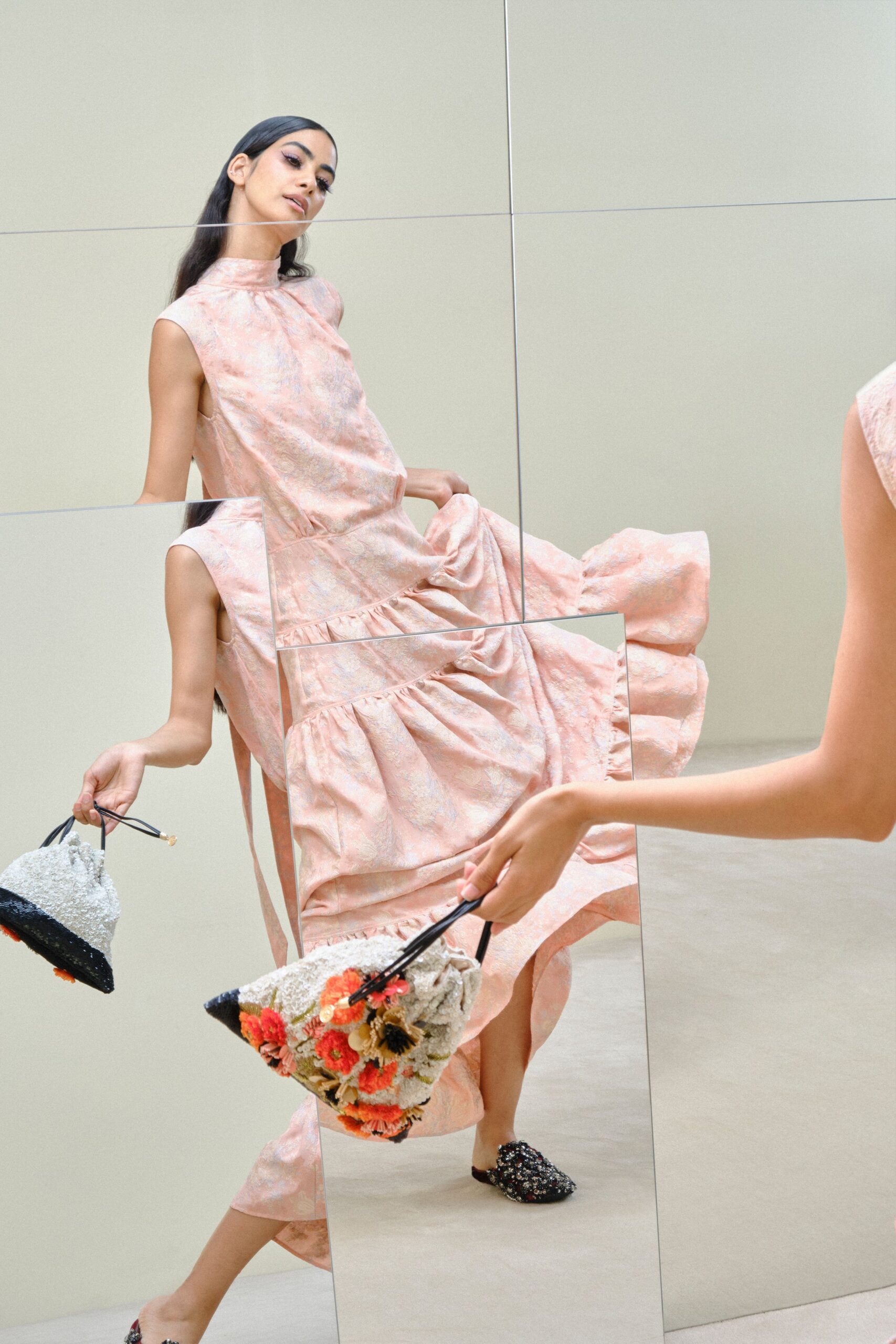 Blush brocade dress with a stand collar and gathered drop-waist tiers. Nubby floral tote with black cord handles and one loose sequin disc. Black beaded pointed flats. Afternoon in a tiled atrium, carrying cake home before the icing slips.