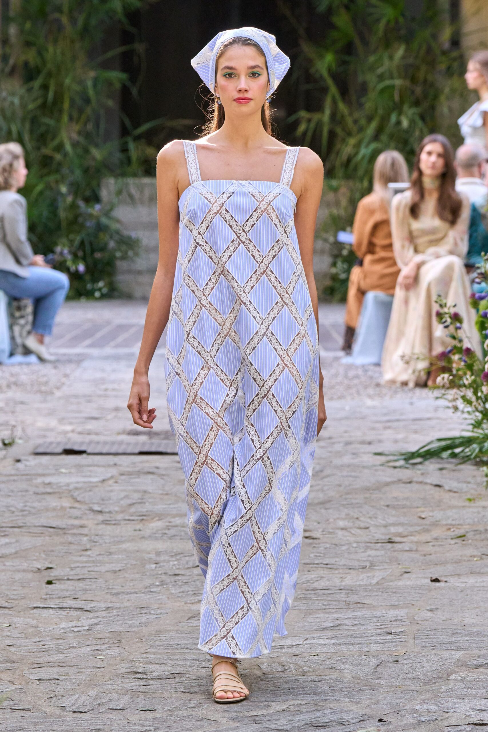 Pale blue striped kerchief, lightly puffed and edged in white lace. Loose column dress in ticking stripes, lace bands crossing into a diamond trellis. Flat nude sandals with narrow straps skimming the toes. Walking the garden path after a church picnic, still carrying sun on your shoulders.