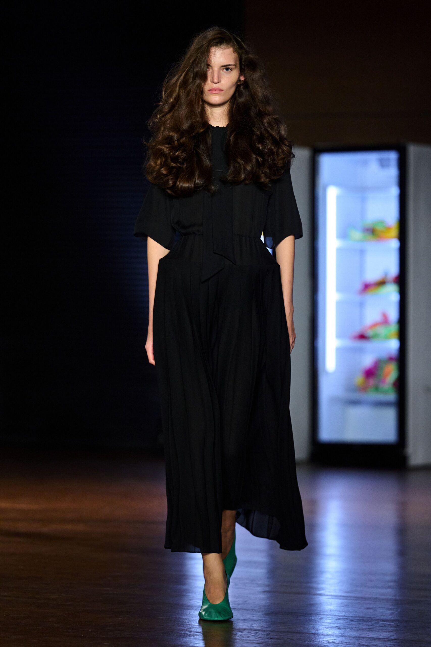 Black crepe midi dress with a loose neck tie and dropped waist seam. Emerald pumps with softly ruched vamps. Walking past the hotel vending machines after the wedding finally thinned out.