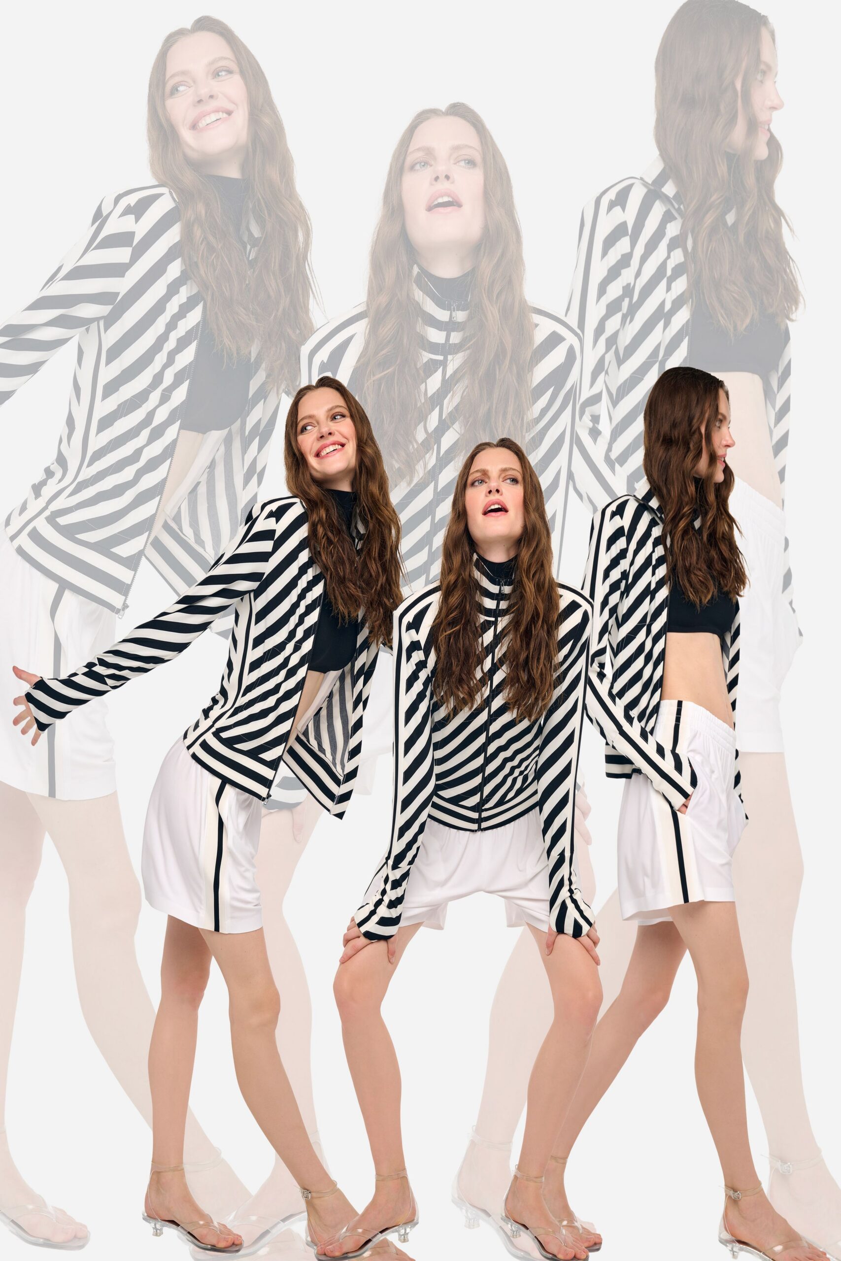 Black-and-white striped knit track jacket, zip pulling the diagonals off-center. Black cropped knit top, clean banded hem at the ribs. White athletic shorts with a single black side stripe. Clear PVC thong sandals on tiny lucite heels. Walking into a hotel gym that still smells faintly of chlorine.