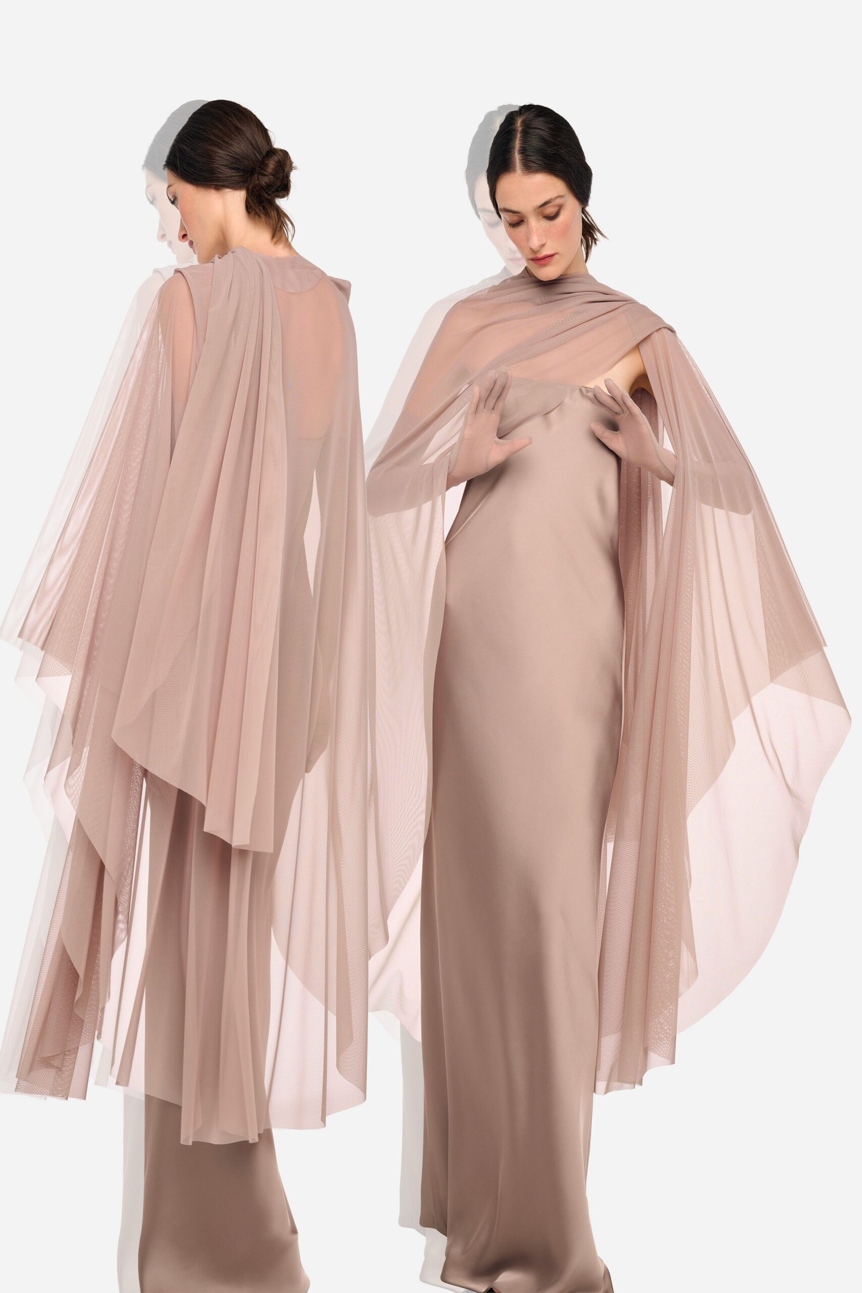 Blush mesh cape draped crosswise at the neck, falling in long pointed panels. Column gown in taupe satin, the straight neckline slightly folding at center. For speaking softly on a terrace after the wedding has emptied out.