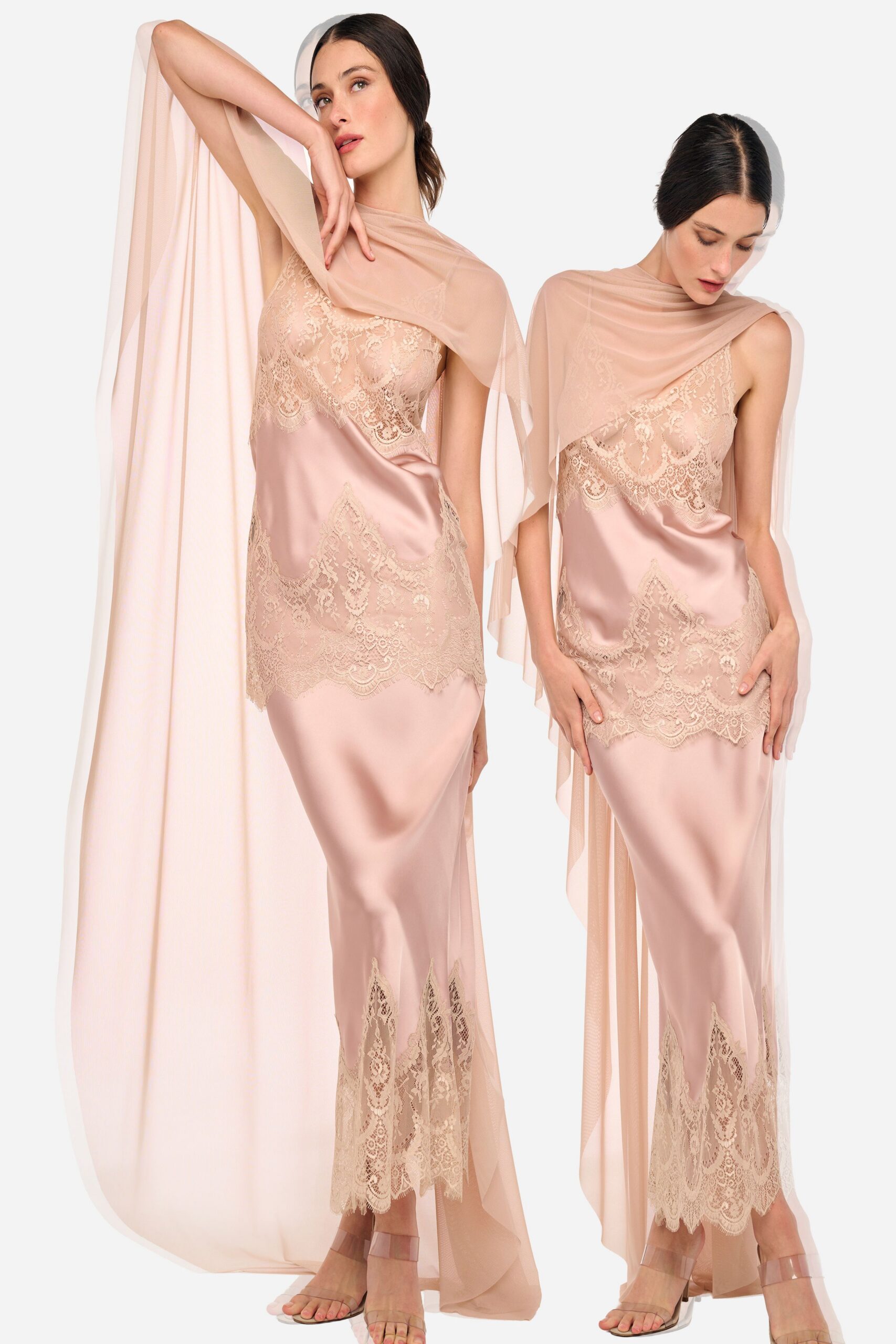 Blush tulle cape draped off one shoulder, pooling in a long train. Powder-pink satin slip dress inset with scalloped lace at bust, hip and calf. Clear vinyl ankle-strap sandals with a barely-there block heel. Hotel corridor at sunrise, carrying yesterday's flowers back to the room.