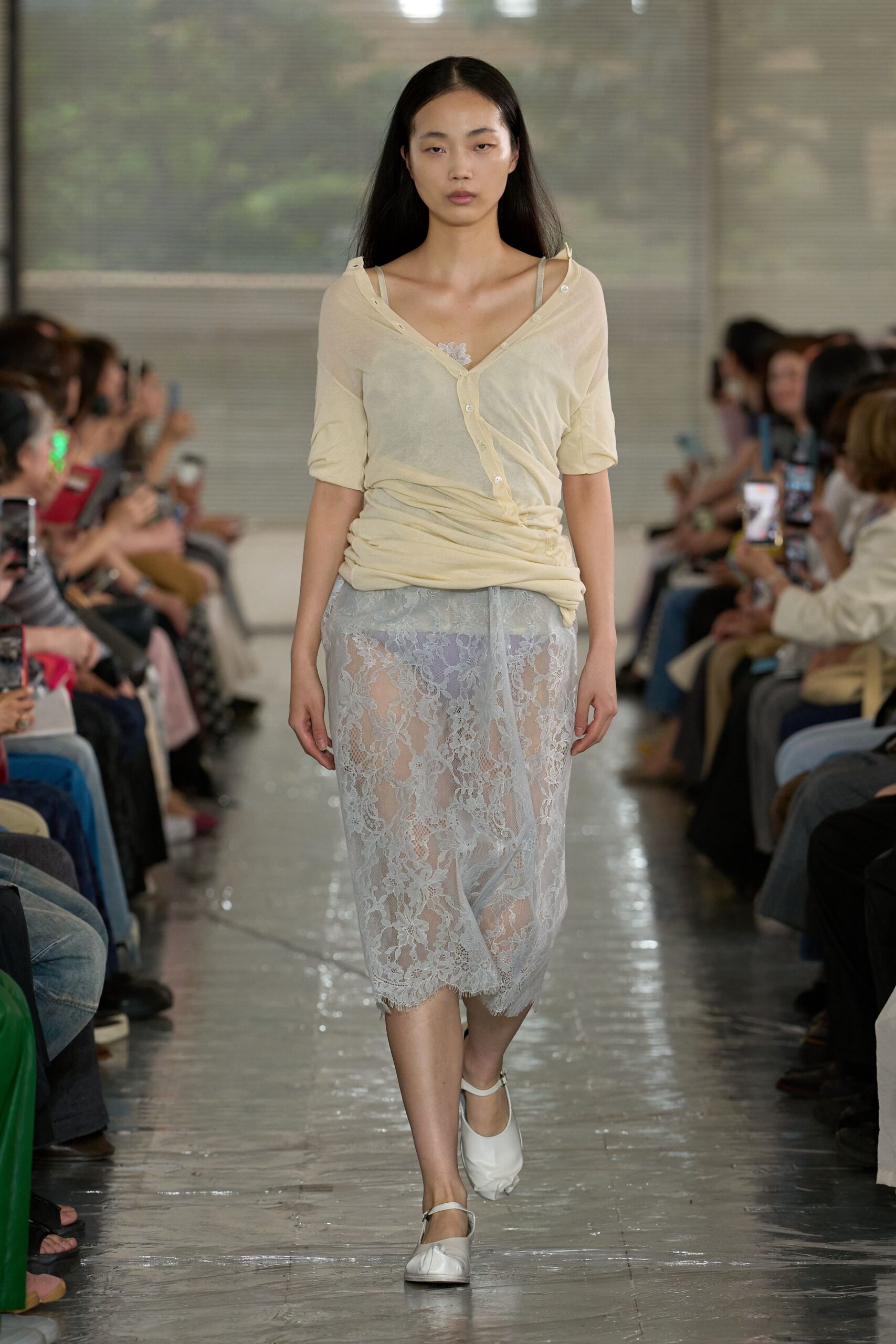Sheer butter cardigan in fine jersey, half-buttoned and slipping off one shoulder over a pale camisole strap. Powder-blue lace skirt with a scalloped eyelash hem, white Mary Janes. Waiting out dawn in a hotel corridor.