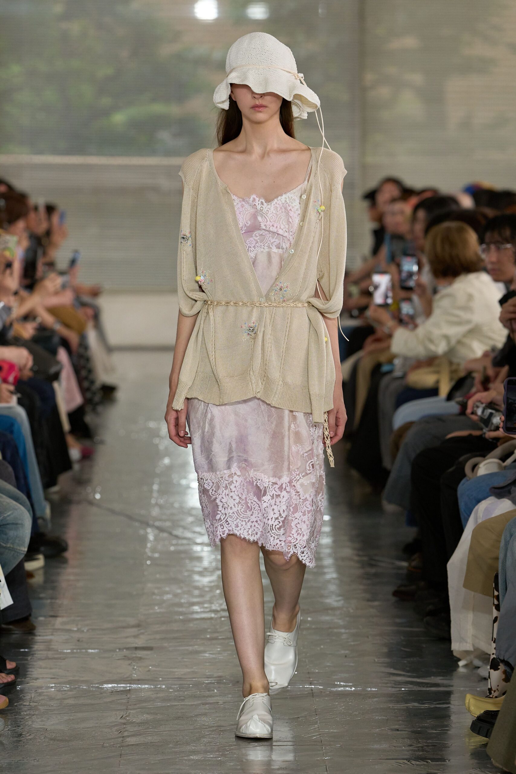 White crochet sunhat with a drooping brim tied off at the side. Blush slip dress in cloudy satin, scalloped with eyelash lace. Oatmeal cardigan in loose open knit, cinched by a braided cord. White lace-up flats. Waiting for the ferry after rain.