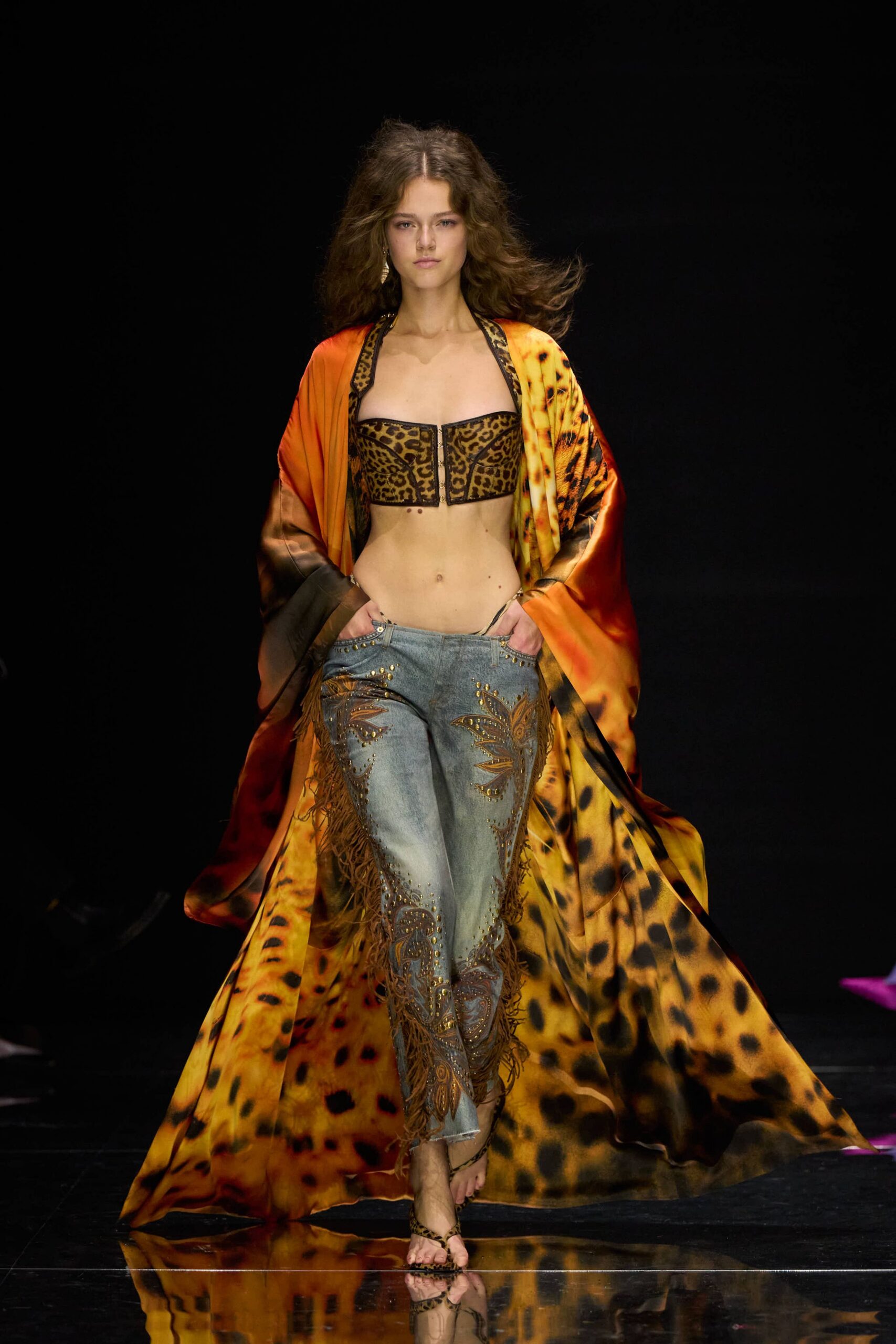 Floor-sweeping satin kimono in burnt orange fading into leopard spots. Leopard bustier with a center zip and narrow black binding. Low-rise faded jeans appliqued with paisley leather and swinging fringe. Leopard thong sandals laced up the ankle. Walking back from a beach bar with sand still stuck to your feet.