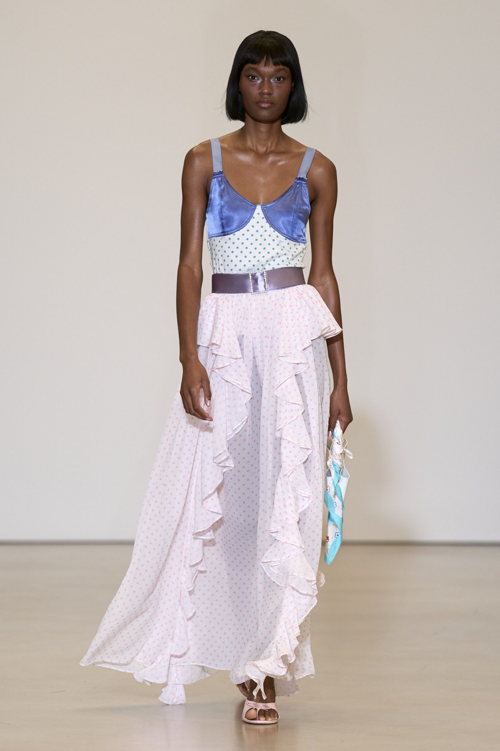 Periwinkle satin bra cups over white jersey dotted in mint. Wide lilac satin belt with a rhinestone buckle. Blush polka-dot chiffon skirt, double ruffles spilling down the front. Rolled silk scarf in powder blue and white. Blush satin toe-ring sandals. For buying peaches at a seaside market before the stalls get loud.