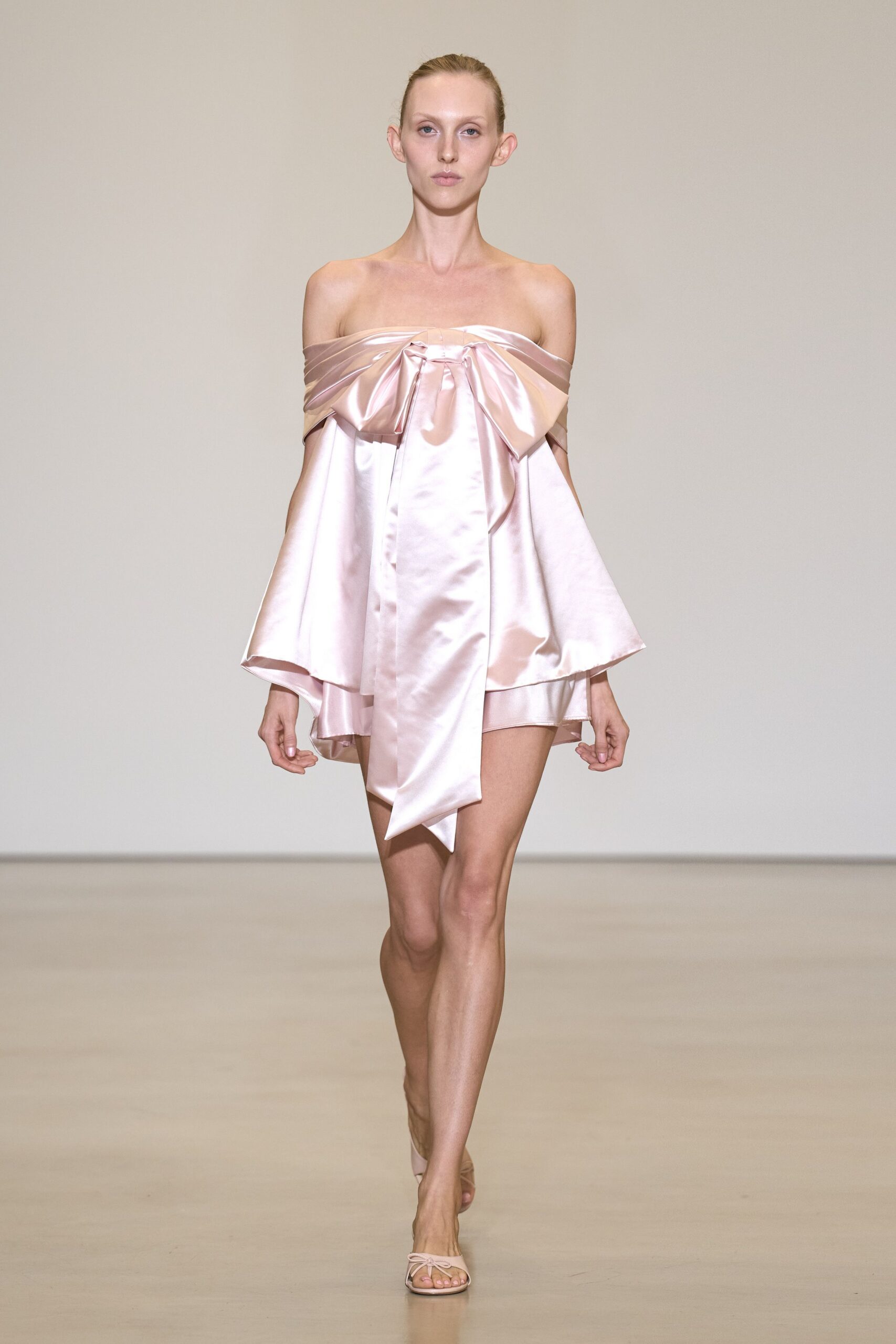 Blush satin mini dress with an off-shoulder bow and long trailing sash. Pale thong sandals with a tiny bow over the toes. For walking back into the wedding suite after everyone else found the pool.