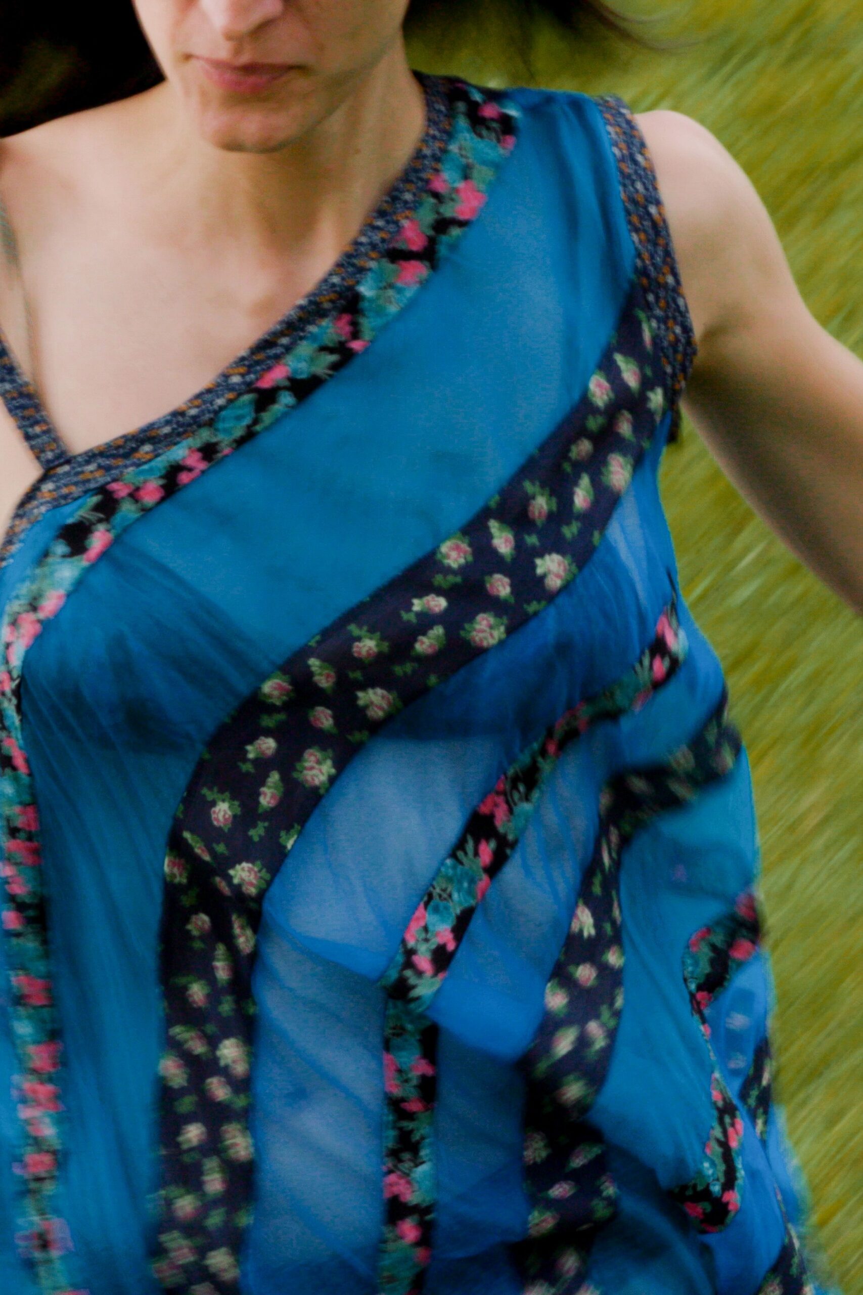 Sheer cobalt dress pieced with diagonal rose-print bands and narrow contrast binding. Running across a lawn after the sprinkler already soaked the hems.