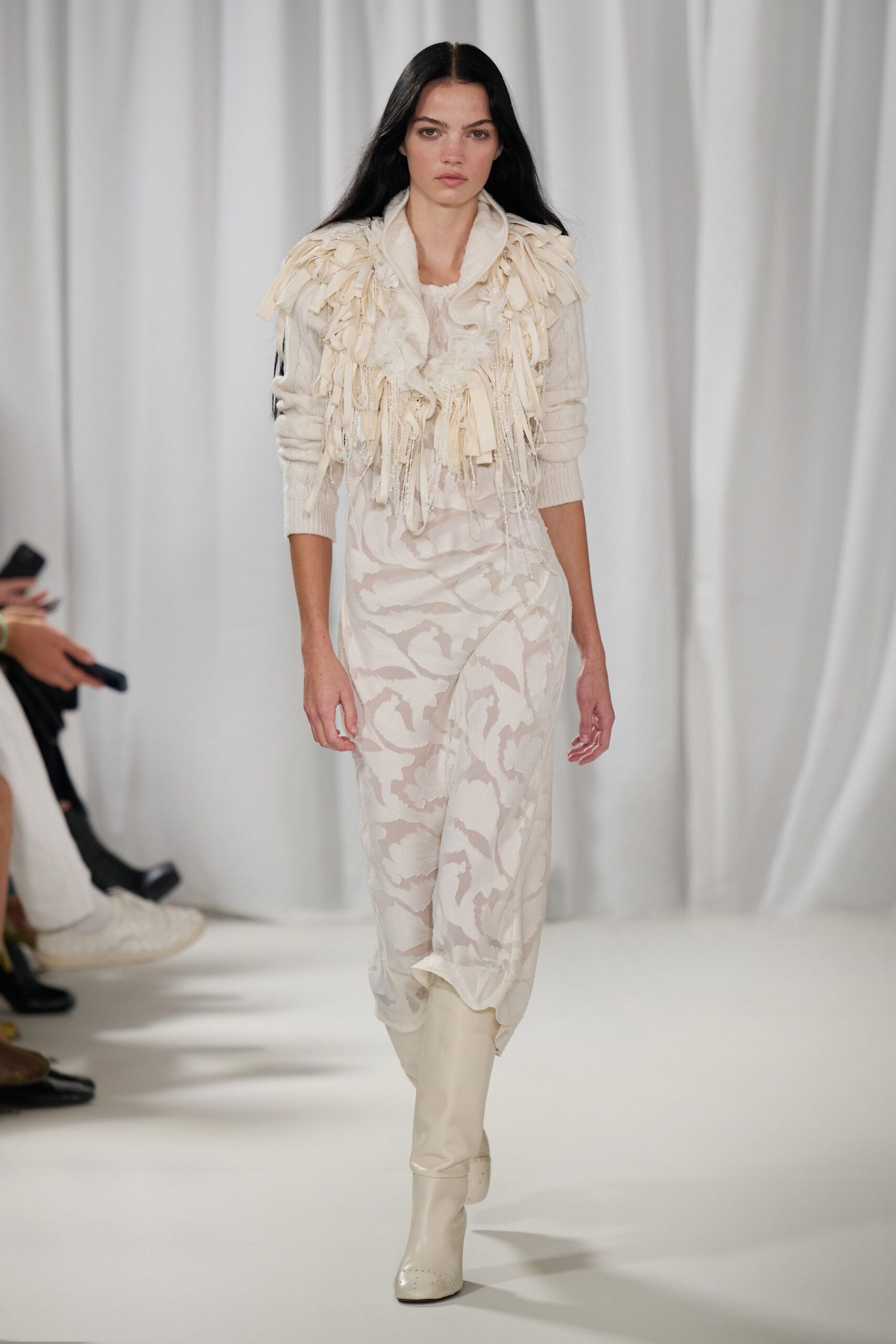 Cream ribbed cardigan shagged with ribbon tassels and looped fringe. Sheer ivory slip dress with cloudy devore swirls and a dipped hem. Milk-white knee boots with tiny perforations across the rounded toe. Morning after the wedding, carrying your shoes back through wet grass.