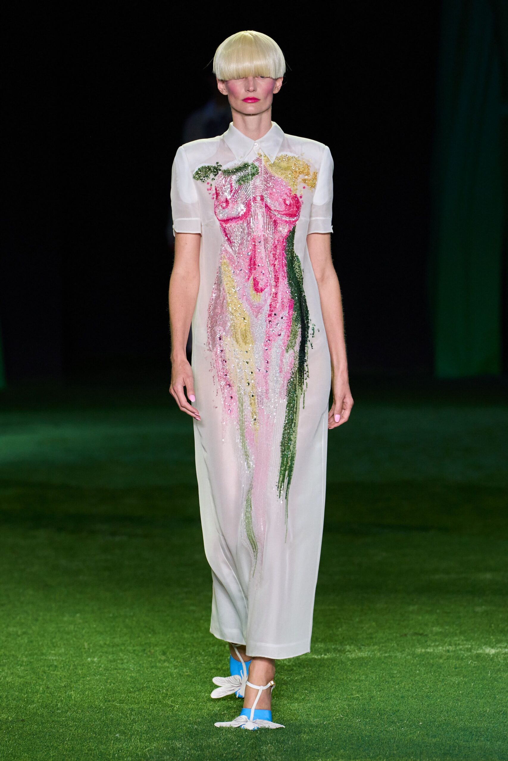 Sheer white shirt-collar column dress with elbow sleeves and a tiny top button. Pink, citron and moss beading forms a dripping torso down the front. Sky-blue T-strap sandals with white petal-like fringed toes. Crossing a lawn after the wedding cake has started to melt.