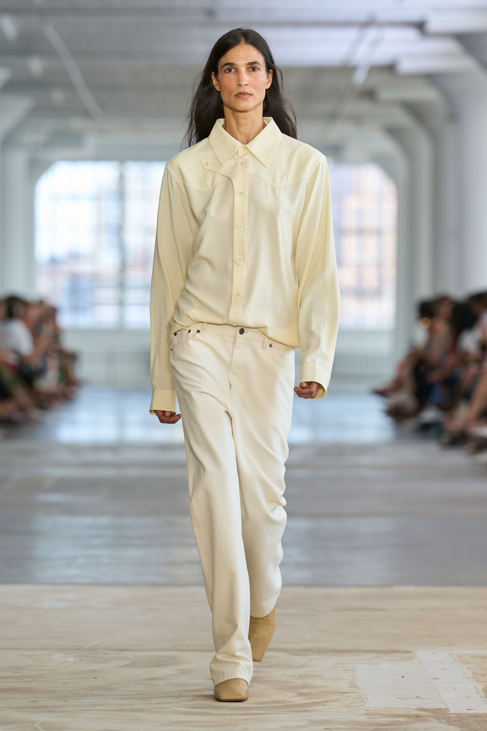 Buttercream shirt with a pointed yoke and one collar tip snapped down. Ecru straight-leg jeans with dark rivets and a low slung rise. Beige square-toe boots peeking under the hem. For crossing a nearly empty office after everyone left for the lake.