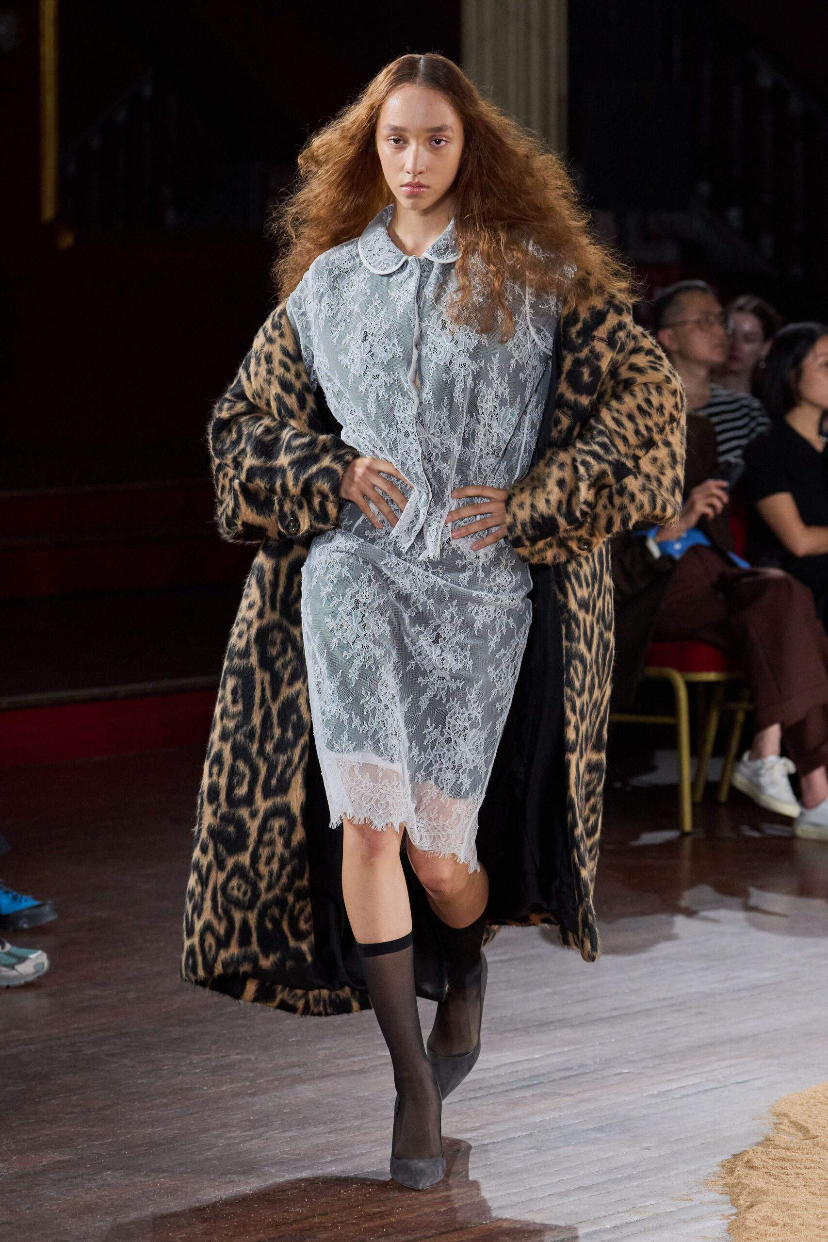 Oversized leopard faux-fur coat, black satin lining flashing at the opening. Powder-blue lace slip dress, scalloped Peter Pan collar and frayed eyelash hem. Sheer black knee-highs. Black suede pumps with a squared vamp. Whatever you throw on for milk at dawn after sleeping in your makeup.