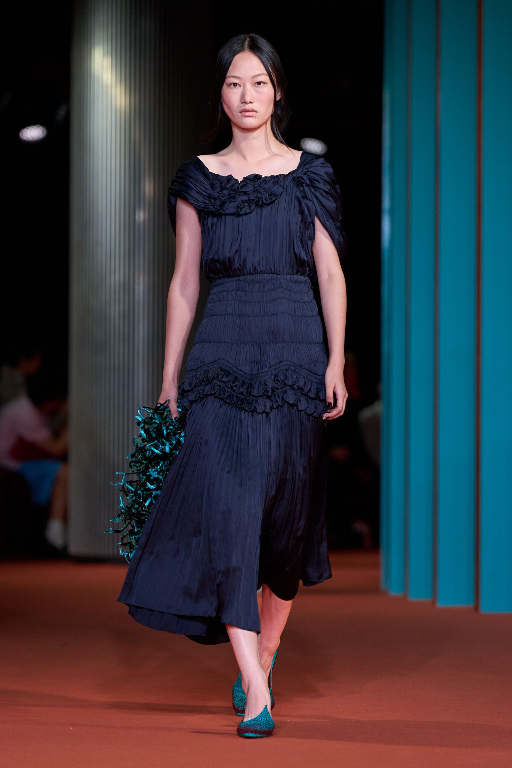Ink-black crinkled satin dress with ruched shoulders and rosettes crowding the neckline. Teal tinsel clutch tangled like gift shred in one hand. Turquoise pumps in a speckled jacquard weave. Walking home from a winter wedding with the centerpiece ribbon in your fist.