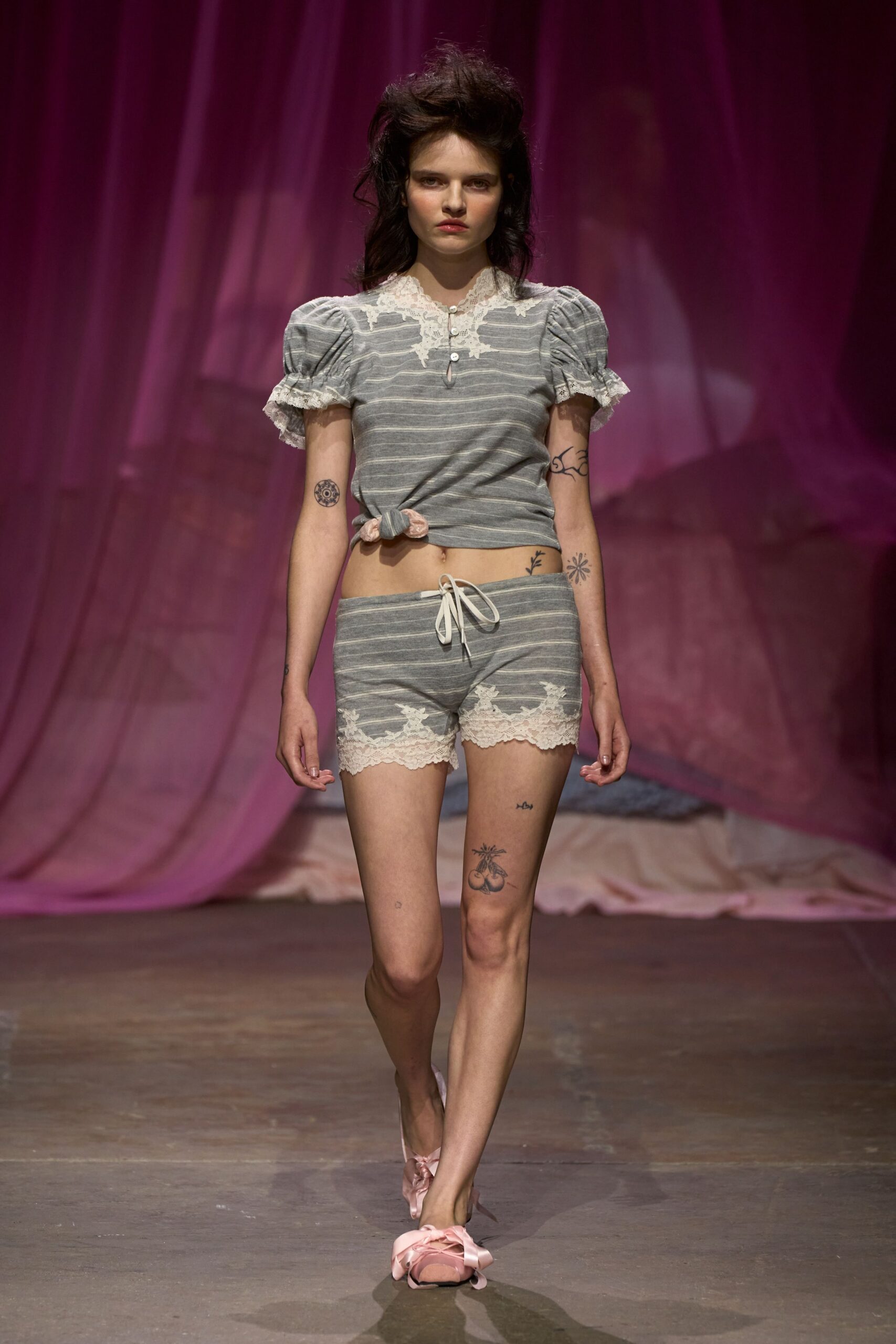 Grey marl striped knit top with puff sleeves and cream lace yoke. Matching low-rise shorts, scalloped lace cuffs and white drawstring bow. Blush satin ballet slippers with oversized ribbon bows. Sunday morning in a boarding house, tea cooling on the windowsill.