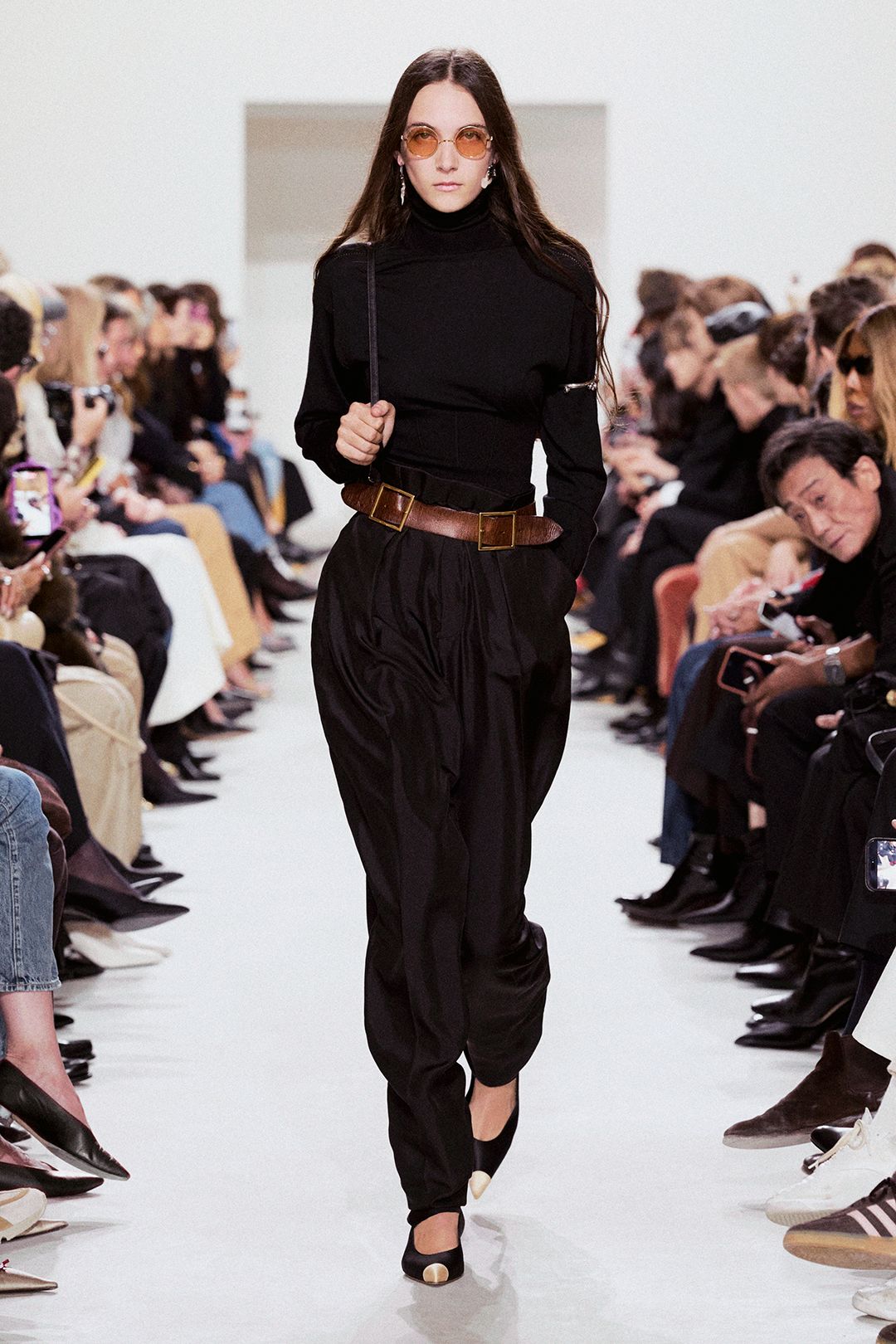 black turtleneck top with draped trousers