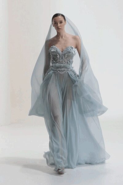 Floor-length mist-blue tulle veil pooling wider than the shoulders. Strapless ice-blue gown with beaded sweetheart corset and split chiffon overskirt. Pale satin peep-toe heels. At the town hall wedding after the church booking fell through.