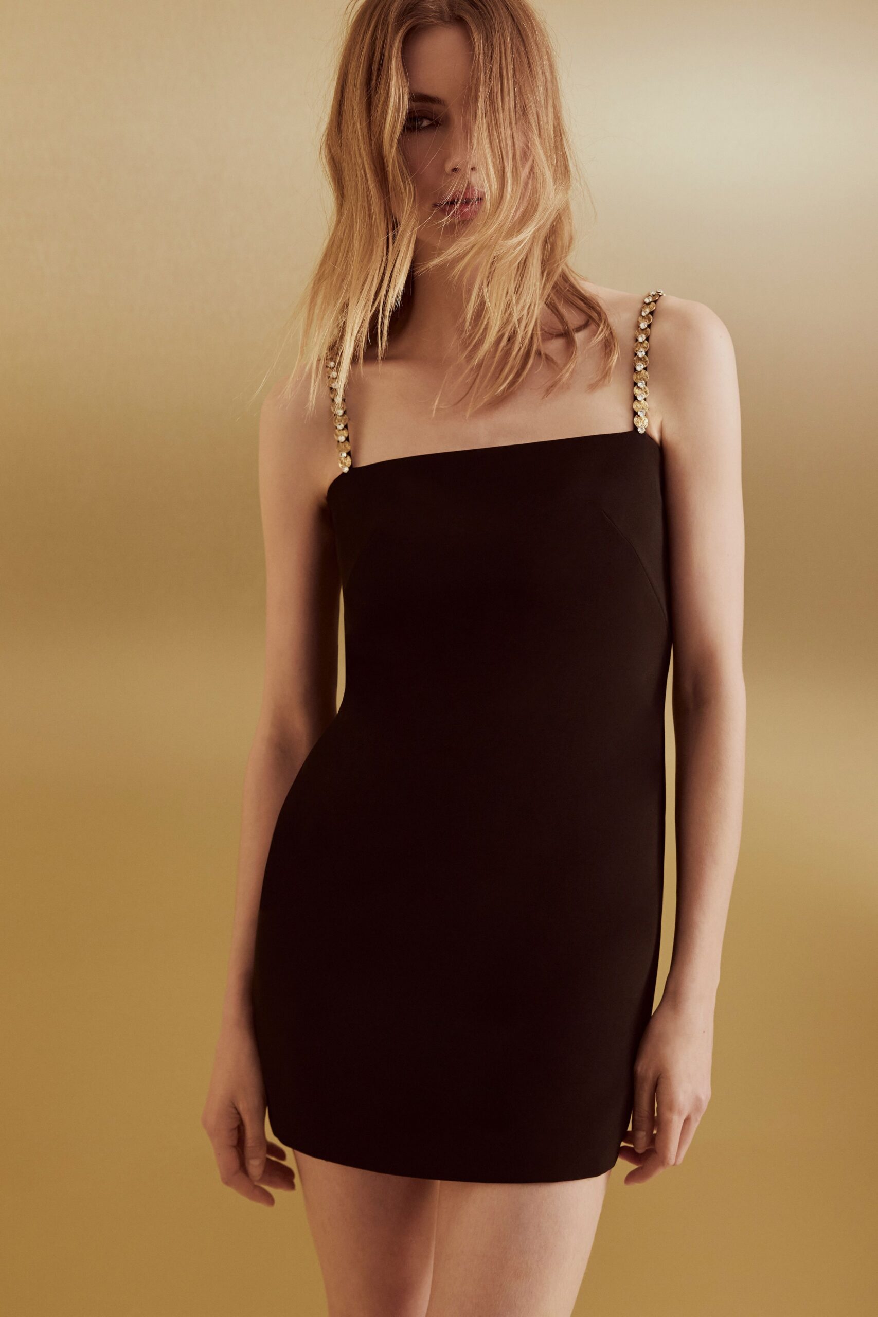 Black column mini with a square neckline and crystal-beaded straps. Hotel corridor carpet just after midnight, keycard warming in your hand.