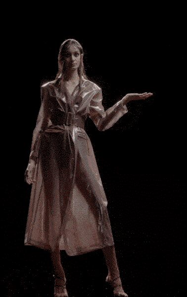 Blush satin shirt-dress with glossy lapels and a self-tie cinching the waist. Sheer organza layer falling from the shoulders to mid-calf. Delicate ankle-strap heels. Holding out the final canapé tray after midnight at a wedding.