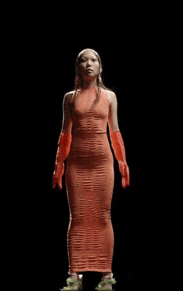 Peach tube-knit halter column, laddered openwork tightening over the hips. Matching opera gloves in the same sheer knit. Pale mules with a fuzzy chartreuse tuft at each toe. Walking out to the motel pool just before the heat breaks.