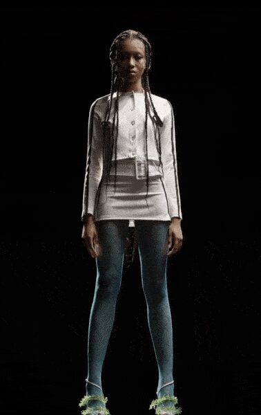 White ribbed cardigan with tiny buttons and a long clear tag hanging. Pale grey mini skirt cut close, waistband sitting flat and high. Powder blue opaque tights. Strappy heels trimmed with chartreuse fluff at the toes. Waiting by the school hall stage door after the recital ends.
