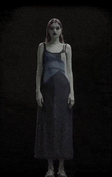 Slate satin slip dress with sheer mesh across the torso and fine straps. Pale open-toe sandals with narrow ankle straps. Standing in the hush before the recital hall doors open.