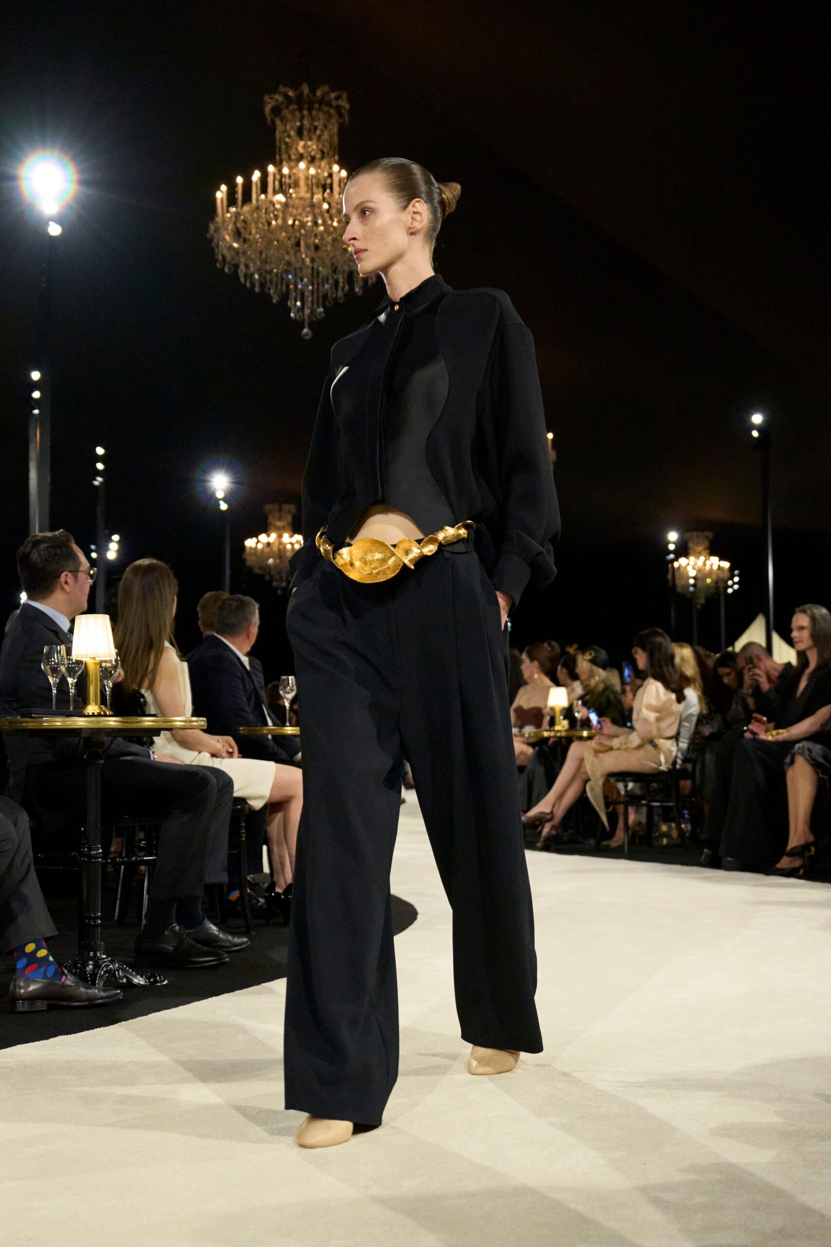 black cutout blouse with sculptural gold belt