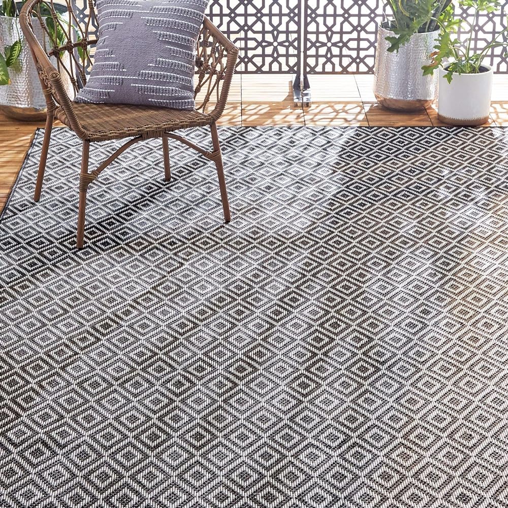 This rug looks great on our back patio (8 x 10). It flattened out almost immediately. The gray / cream print is perfect with our denim blue wicker couch set. It smelled weird at first, probs because the way its packaged/stored, but after a couple rains the smell has faded. Would definitely recommend this rug for the price!